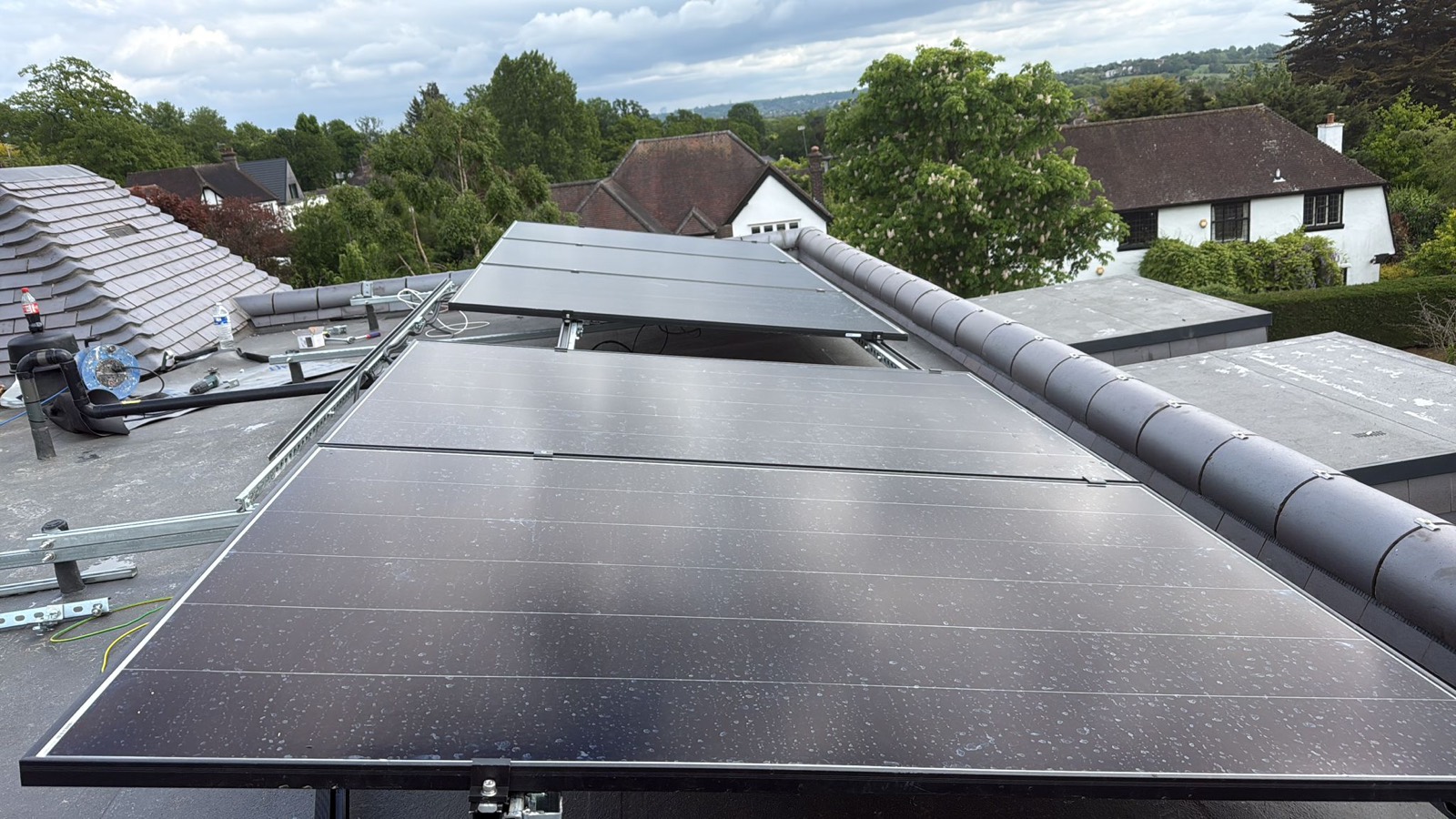 All-black solar panels on a flat roof with views over the surrounding neighbourhood